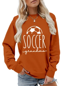 Close-up of Soccer Grandma graphic print on burnt orange long sleeve crewneck sweatshirt