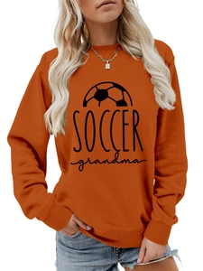 Close-up of ribbed crewneck and 'SOCCER grandma' black print on orange sweatshirt