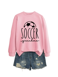Detail view of pink Soccer Grandma sweatshirt with distressed denim shorts