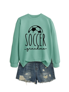 Close-up of mint green Soccer Grandma sweatshirt with high-waist distressed denim shorts