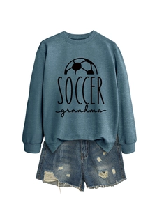 Flat lay of a grey soccer grandma sweatshirt paired with distressed blue denim shorts