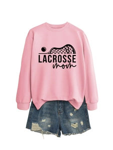 Flat lay of pink Lacrosse Mom sweatshirt paired with distressed blue denim shorts