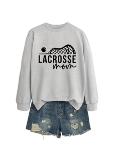 Flat lay of light grey Lacrosse Mom sweatshirt and blue distressed denim shorts