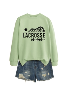 Detail of light green Lacrosse Mom sweatshirt paired with distressed denim shorts