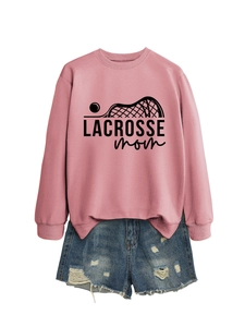 Detailed view of pink Lacrosse Mom sweatshirt and distressed denim shorts on white background