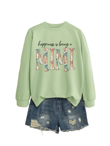 Dettaglio felpa verde menta con stampa floreale MIMI e shorts in denim invecchiato
