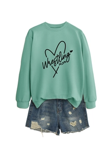 Detail of mint green sweatshirt with Wrestling Mom print and distressed denim shorts