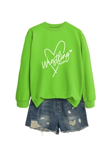 Close-up of Wrestling mom heart print on neon green sweatshirt with distressed denim shorts