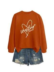 Flat lay of an orange Wrestling Mom sweatshirt with distressed denim shorts