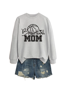 Detailed flat lay of a light grey Basketball Mom sweatshirt and blue distressed denim shorts