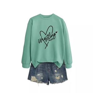 Mint green Wrestling Mom sweatshirt paired with distressed blue denim shorts in a flat lay