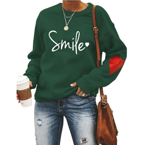 Detail of red heart patch on dark green sweatshirt sleeve with Smile print design