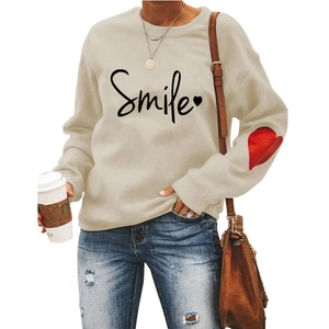 Detail of beige sweatshirt with Smile print and red heart patch on sleeve for women