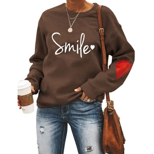 Detail of smile print and red heart patch on long sleeve dark brown sweatshirt