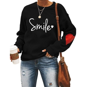 Detail of red heart patch on sleeve of a black casual crewneck sweatshirt for women