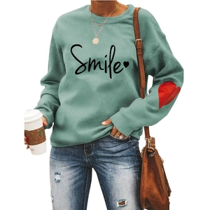 Detail of light green sweatshirt with Smile text and red heart print on the sleeve
