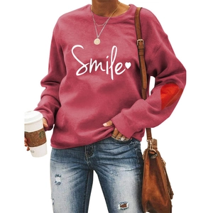 Detail of smile lettering and heart patch on sleeve of rose pink women sweatshirt