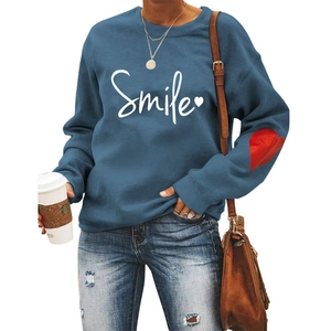 Detail of navy sweatshirt featuring white Smile print and red heart on sleeve with model