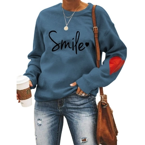 Detail of navy blue sweatshirt with Smile print and red heart patch on sleeve