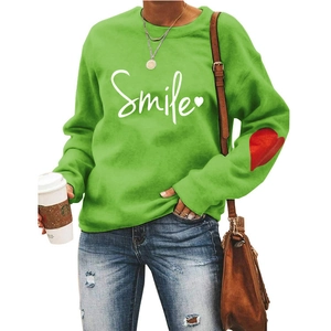 Detail of green Smile sweatshirt with red heart print on the sleeve and white chest logo