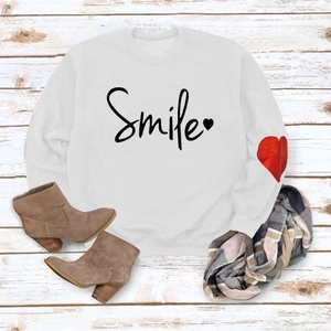 Detail of white cotton sweatshirt with smile text and red heart print on the sleeve