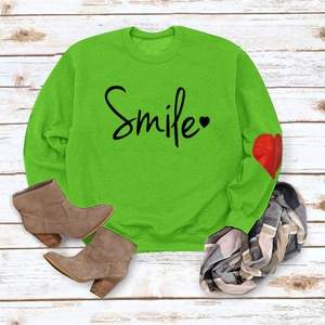 Flat lay of green Smile heart sweatshirt with plaid scarf and brown suede ankle boots