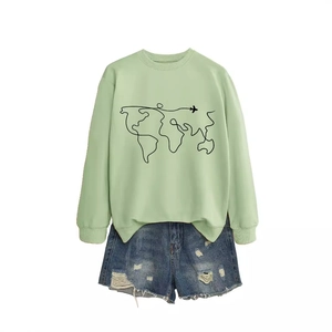 Mint green crew neck sweatshirt with world map print and blue distressed denim shorts