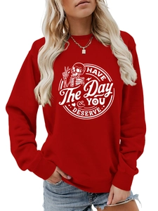Detail of white skull graphic and 'HAVE THE DAY YOU DESERVE' slogan on red sweatshirt