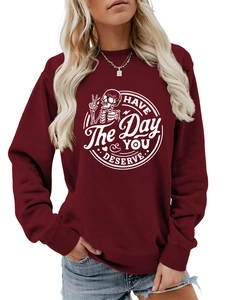 Detail of burgundy long sleeve sweatshirt with white skull print and slogan