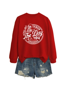 Flat lay of red sweatshirt with skull graphic and distressed denim shorts ensemble