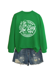 Detail of green crewneck sweatshirt with Have The Day You Deserve slogan and skull print