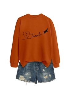Flat lay of an orange Travel sweatshirt with aircraft print and ripped denim shorts