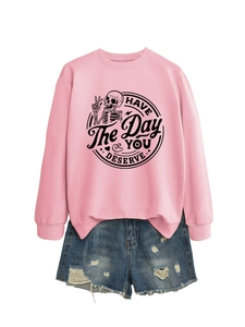 Detail of pink sweatshirt with Have The Day You Deserve print and ripped denim shorts
