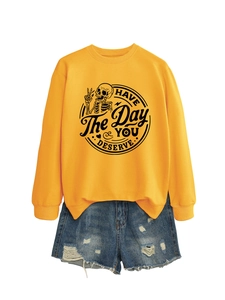 Detail of yellow long sleeve sweatshirt with skull graphic and ripped denim shorts