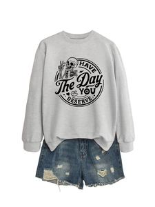 Detail of light grey sweatshirt with skeleton print and distressed denim shorts