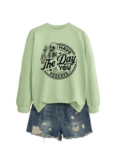Close-up of light green sweatshirt with skull graphic and Have the day you deserve text