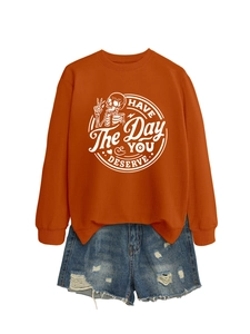 Detail of caramel orange sweatshirt with white skull hand print and motivational text