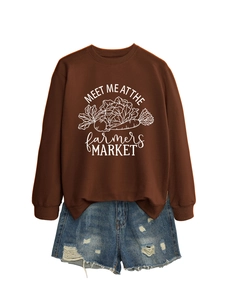 Détail d'un pull marron avec imprimé blanc vintage et short en jean aux bords effilochés