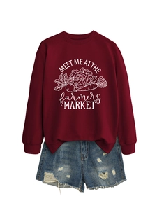 Détail d'un sweat-shirt bordeaux avec graphique blanc et un short en jean usé