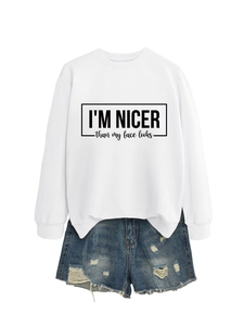 Detailed view of white sweatshirt with I'm nicer than my face looks slogan print