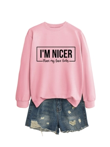 Detail of pink crewneck sweatshirt with black slogan print and distressed denim shorts