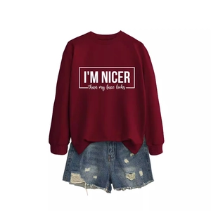 Burgundy crewneck sweatshirt with slogan and distressed denim shorts street style outfit