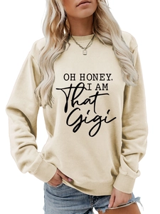 Detail of beige crewneck sweatshirt featuring black 'OH HONEY, I AM That Gigi' print