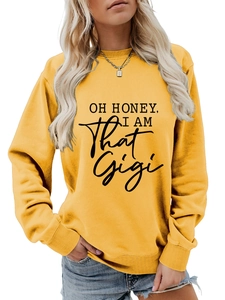 Detail of rib-knit cuffs and letter print on bright yellow crewneck sweatshirt