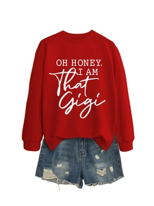 Flat lay of red sweatshirt with OH HONEY text and distressed blue denim shorts