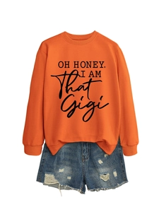 Flat lay of an orange 'OH HONEY' slogan sweatshirt paired with distressed denim shorts