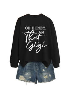 Detail of black sweatshirt with Oh Honey I Am That Gigi text and distressed denim shorts