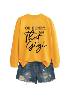 Detail view of ginger yellow sweatshirt with OH HONEY I AM THAT GIGI print and denim shorts
