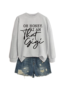 Detail of grey crewneck sweatshirt with black slogan and distressed denim shorts