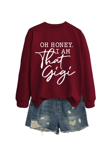 Flat lay of a burgundy crewneck sweatshirt with 'Oh Honey' print and ripped denim shorts
